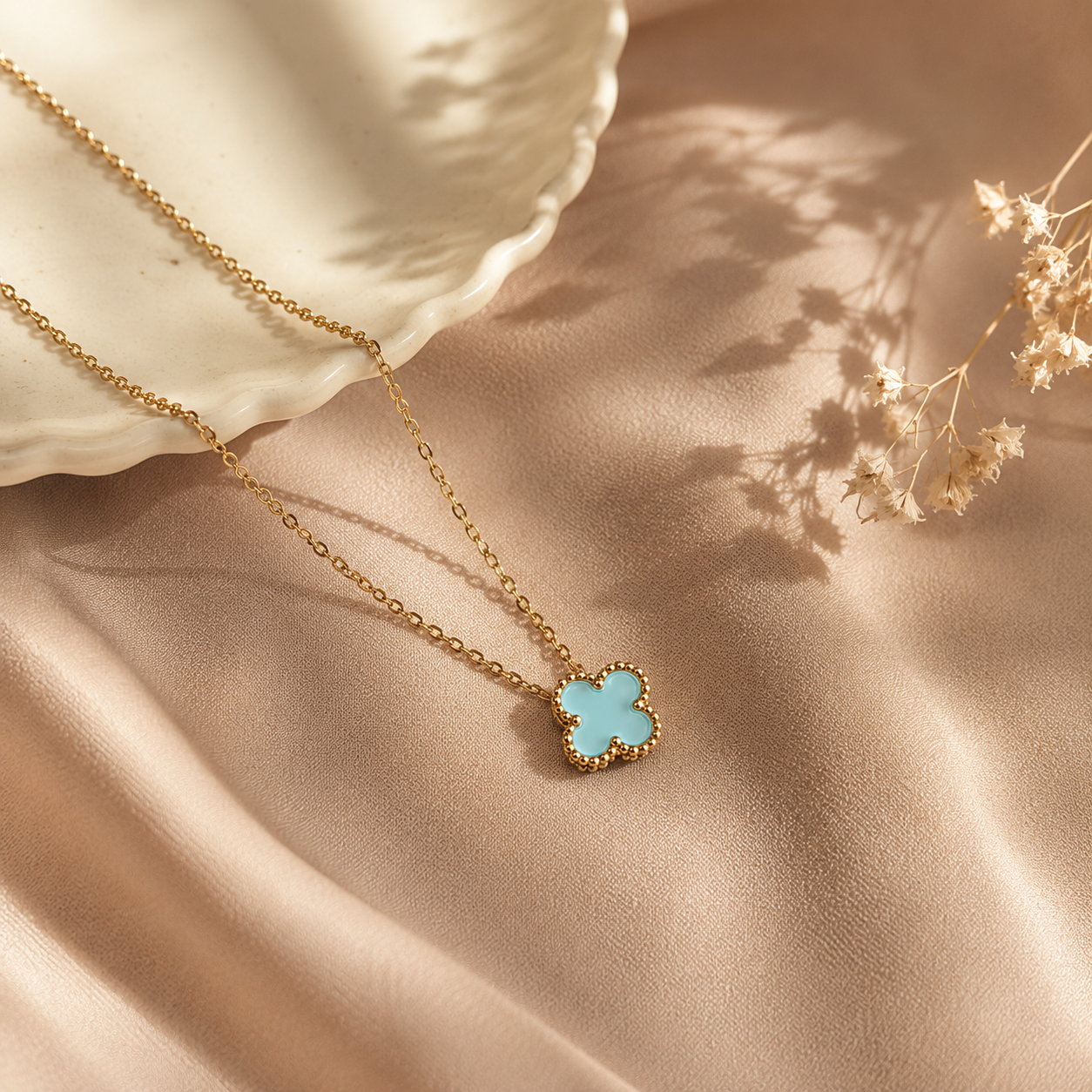 Hochwertige Edelstahl-Kette in goldenen, modernen Kleeblatt-Design in einem frischen Türkiston. Langlebig, wasserfest, hypoallergen und alltagstauglich.