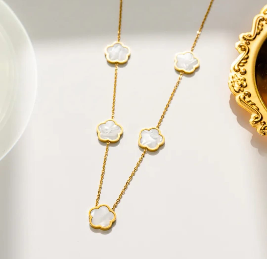 Hochwertige Edelstahl-Kette in goldenen, modernen Kleeblatt-Design in edlem Perlmutt-weiß. Langlebig, wasserfest, hypoallergen und alltagstauglich.