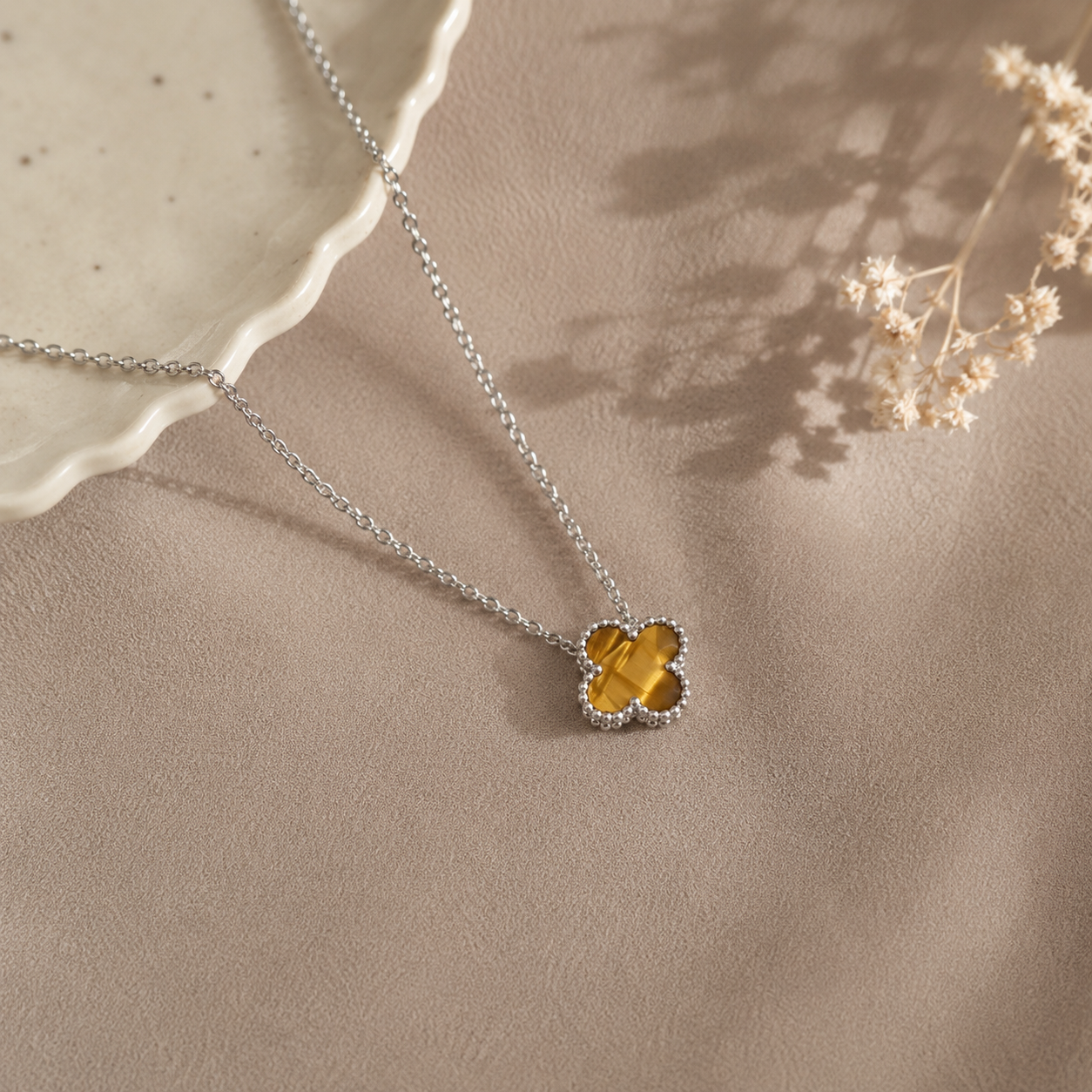 Hochwertige Edelstahl-Kette mit weißgoldenen Kleeblatt-Design in schlichten, aber ausdrucksstarken braun-beige. Langlebig, wasserfest, hypoallergen und alltagstauglich.