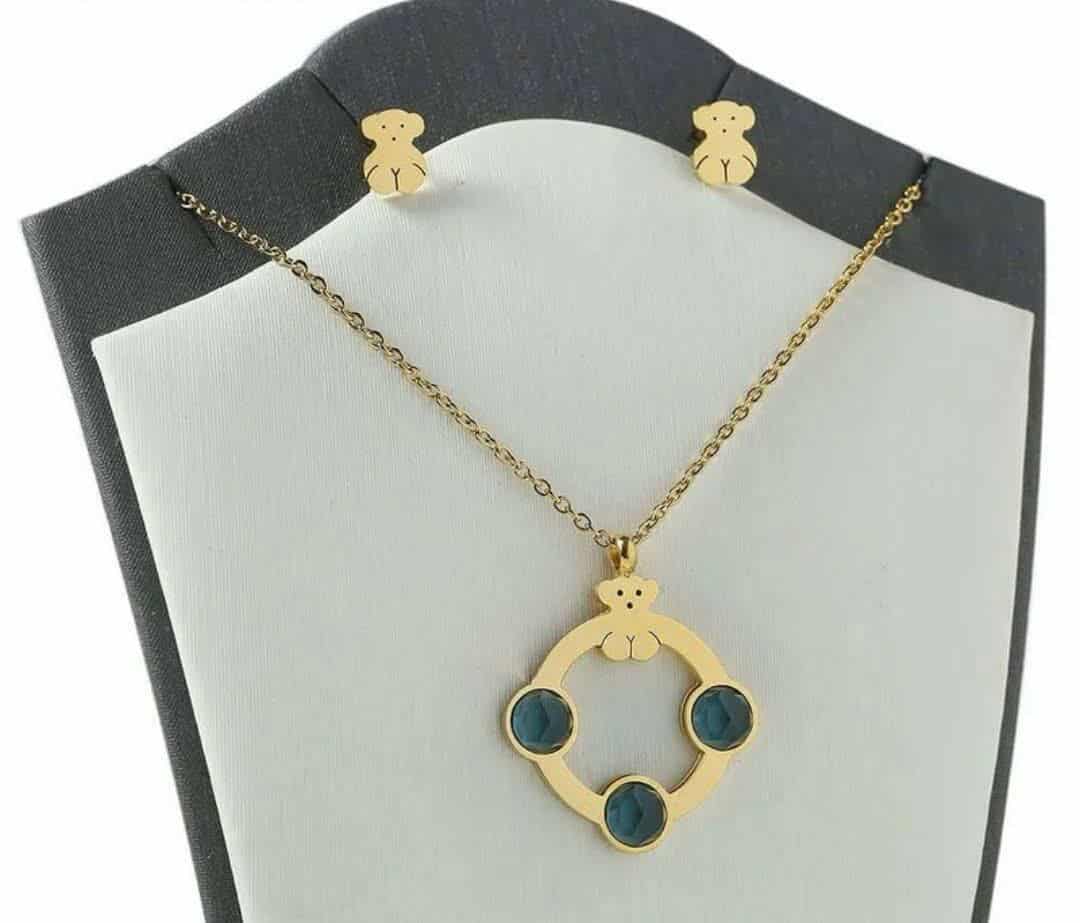 Hochwertiges Edelstahl-Set bestehend aus einer filigranen, goldenen Kette in Kreisform mit grünen Zirkonia und passenden Ohrsteckern in Bärchen-Form. Langlebig, wasserfest, hypoallergen und alltagstauglich.