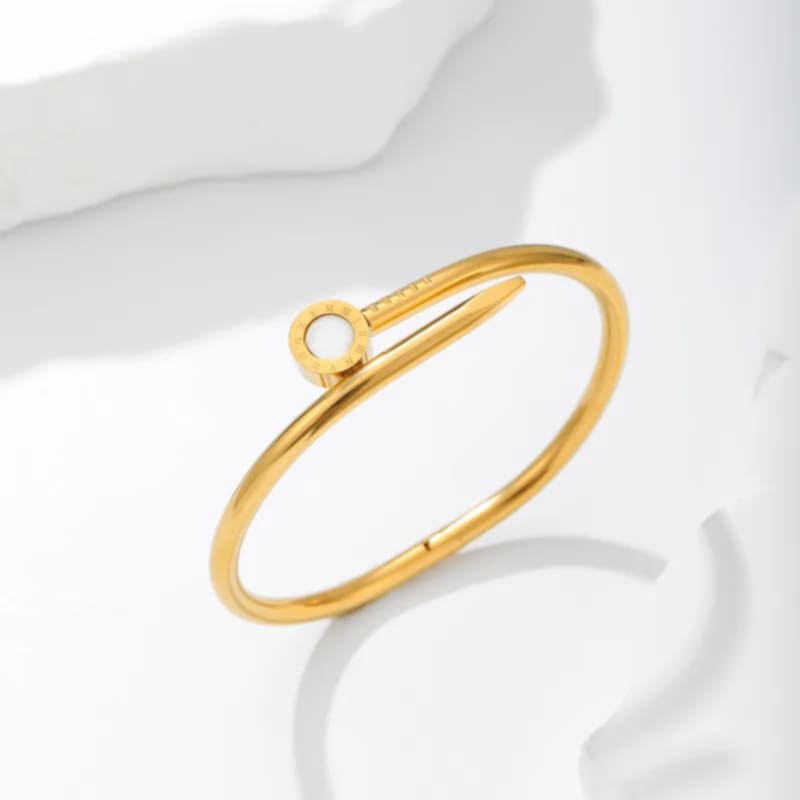 Hochwertiger Edelstahl Armreif in edlen goldenen, minimalistischen Design mit runden weißen Element graviert mit römischen Ziffern. Langlebig, wasserfest, hypoallergen und alltagstauglich.