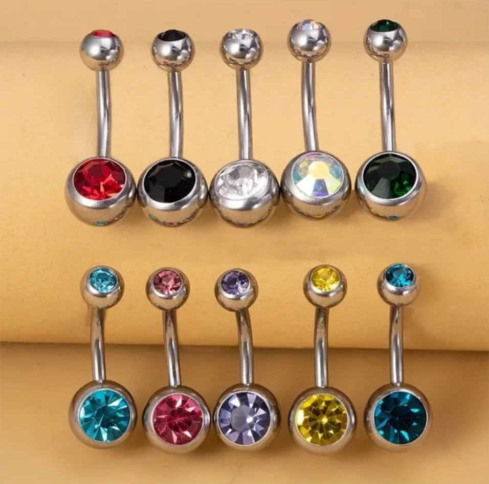 Hochwertiges Edelstahl Bauchnabelpiercing mit bunter Zirkonia-Kugel. Langlebig, nickelfrei, glanzbeständig und wasserfest.