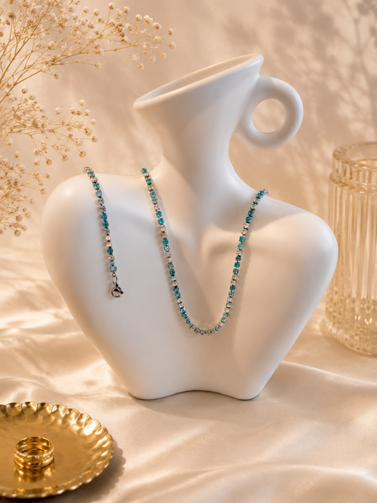 Hochwertiges Edelstahl-Set bestehend aus einer Kette und Armband in Weißgold. Femininer Stil mit zahlreichen, feinen klaren und türkisen Zirkonia-Steinen. Langlebig, wasserfest, hypoallergen und alltagstauglich.