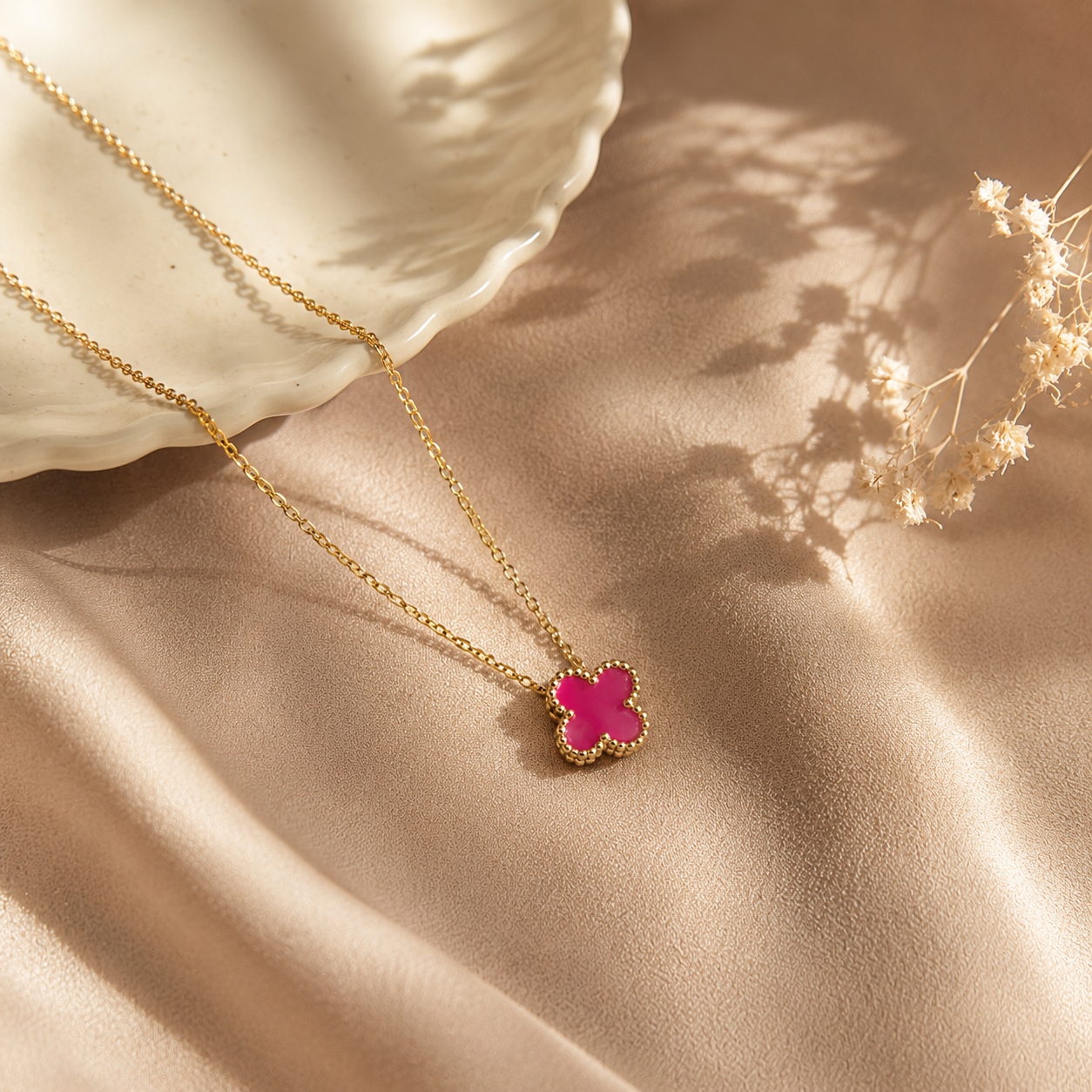Hochwertige Edelstahl-Kette in goldenen, modernen Kleeblatt-Design in einem frischen Beerenton. Langlebig, wasserfest, hypoallergen und alltagstauglich.