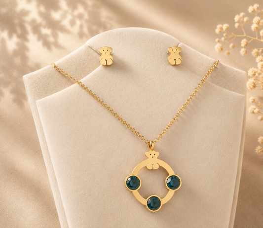 Hochwertiges Edelstahl-Set bestehend aus einer filigranen, goldenen Kette in Kreisform mit grünen Zirkonia und passenden Ohrsteckern in Bärchen-Form. Langlebig, wasserfest, hypoallergen und alltagstauglich.