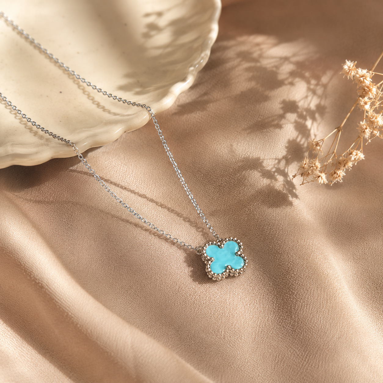Hochwertige Edelstahl-Kette mit weißgoldenen Kleeblatt-Design in schlichten, aber ausdrucksstarken Türkis. Langlebig, wasserfest, hypoallergen und alltagstauglich.