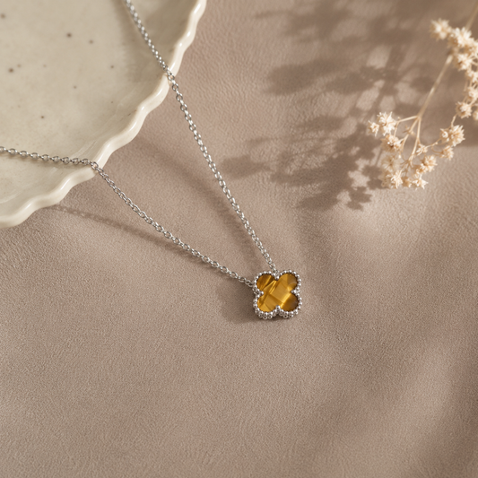 Hochwertige Edelstahl-Kette mit weißgoldenen Kleeblatt-Design in schlichten, aber ausdrucksstarken braun-beige. Langlebig, wasserfest, hypoallergen und alltagstauglich.