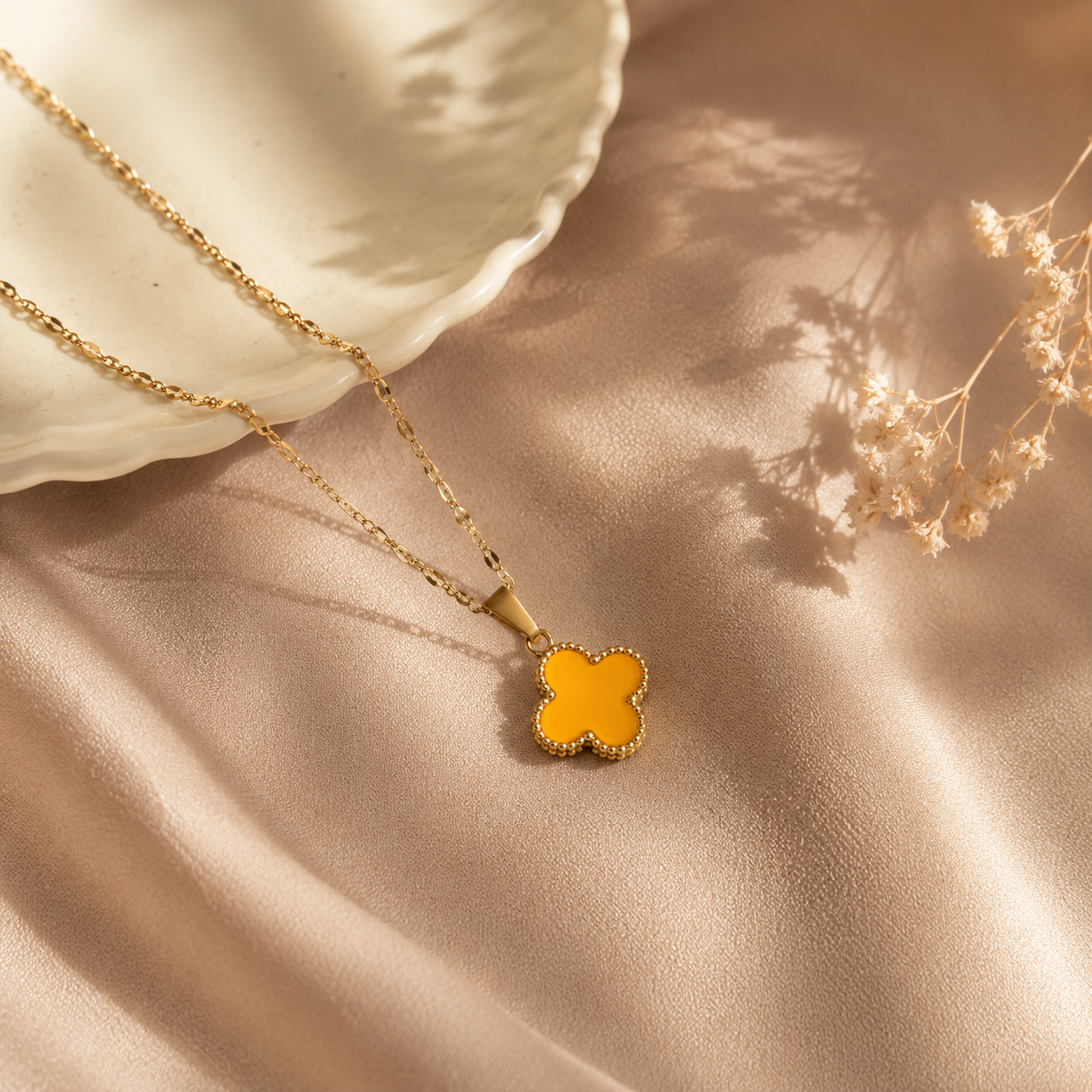 Hochwertige Edelstahl-Kette in goldenen, modernen Kleeblatt-Design in einem frischen Orangeton. Langlebig, wasserfest, hypoallergen und alltagstauglich.