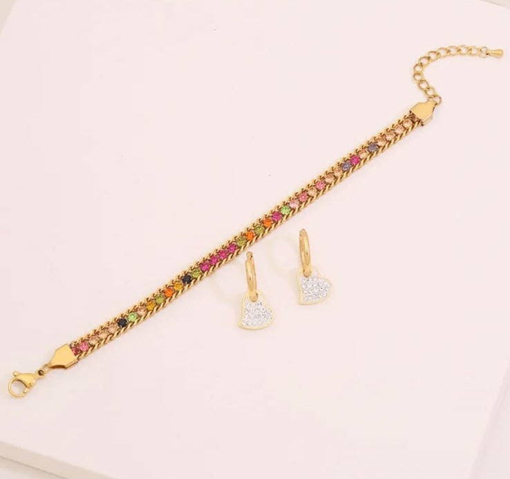 Hochwertiges Edelstahl-Set bestehend aus Creolen mit Anhänger und Armband in Gold. Femininer Stil mit zahlreichen, feinen bunten Zirkonia-Steinen. Langlebig, wasserfest, hypoallergen und alltagstauglich.