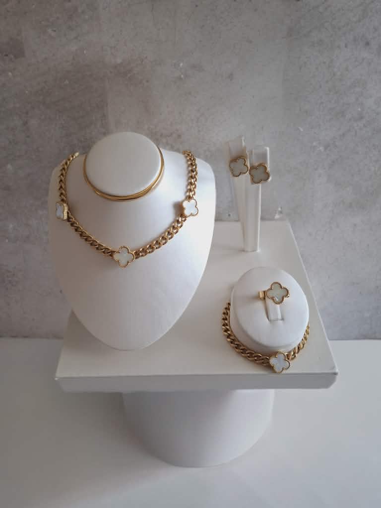 Hochwertiges vierteiliges Edelstahl-Set bestehend aus einer Kette passenden Ohrsteckern, Ring und Armband in edlen, goldenen, weißen Kleeblättern. Langlebig, wasserfest, hypoallergen und alltagstauglich.