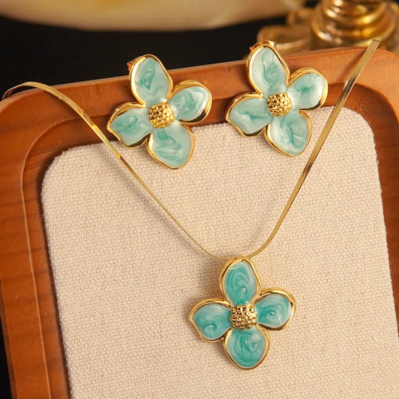 Hochwertiges Edelstahl-Set bestehend aus einer filigranen, goldenen Kette mit edlen Blütenanhänger und passenden Ohrsteckern. Elegant und feminin. Langlebig, wasserfest, hypoallergen und alltagstauglich.