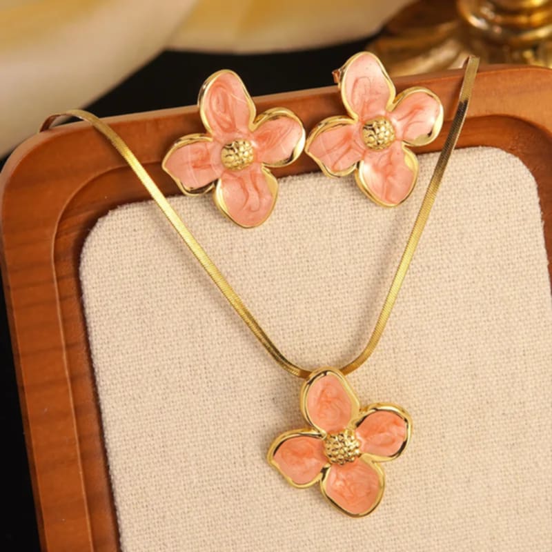 Hochwertiges Edelstahl-Set bestehend aus einer filigranen, goldenen Kette mit edlen Blütenanhänger und passenden Ohrsteckern. Elegant und feminin. Langlebig, wasserfest, hypoallergen und alltagstauglich.