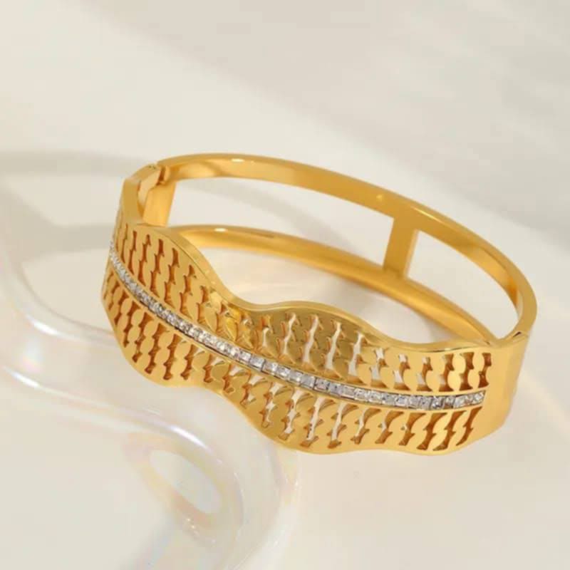 Hochwertiger Edelstahl Armreif in edlen goldenen, großen auffälligen Wellen- Design verziert mit zahlreichen Zirkonia. Highlight am Handgelenk. Langlebig, wasserfest, hypoallergen und alltagstauglich.